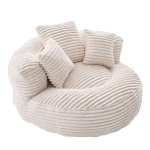 Sillón redondo de pana color crema con cojines.