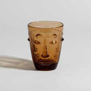 Vaso de vidrio marrón con cara en relieve